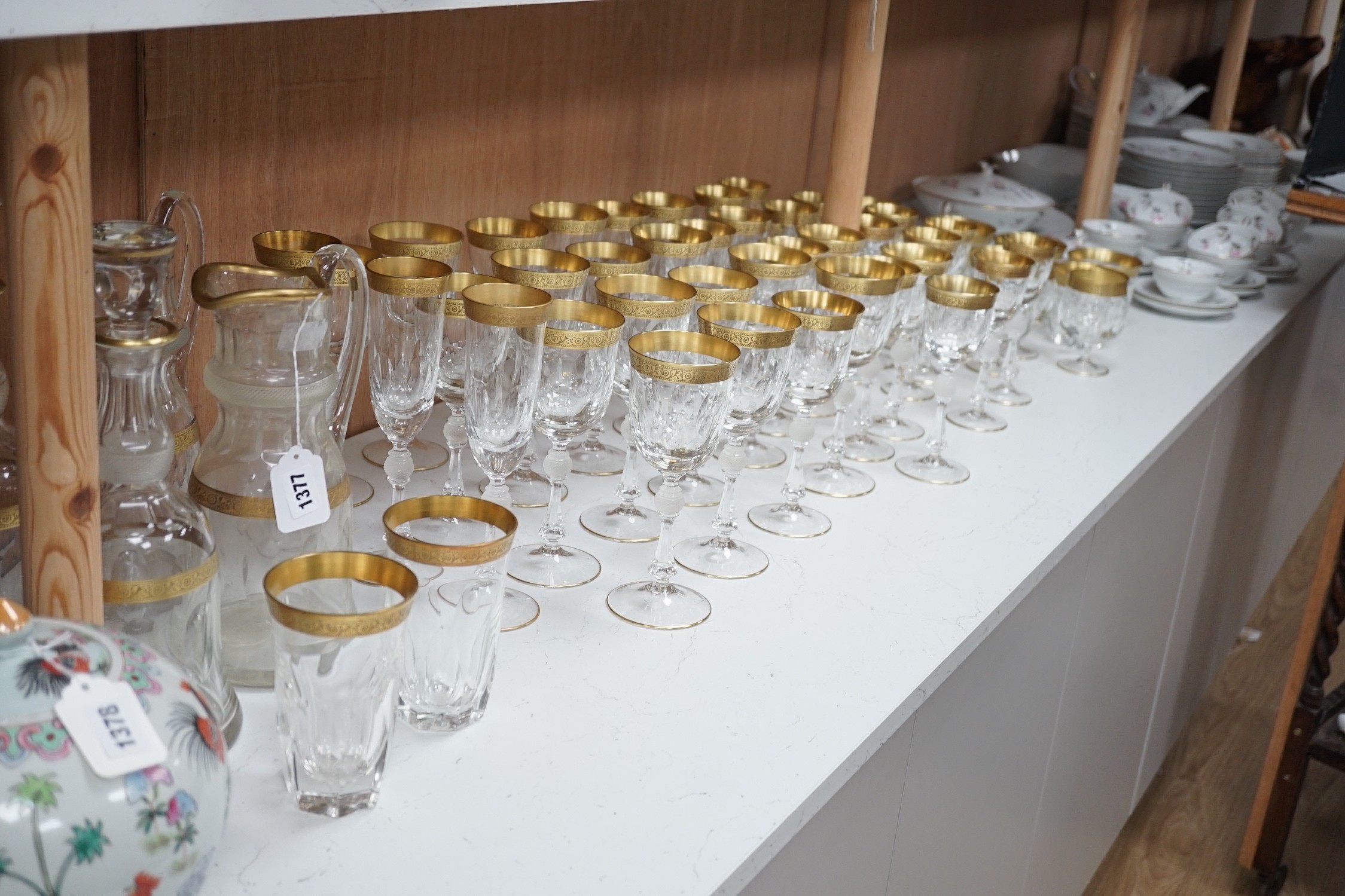A Harrods retailed parcel gilt and cut and moulded suite of drinking glasses, two decanters and two carafes
